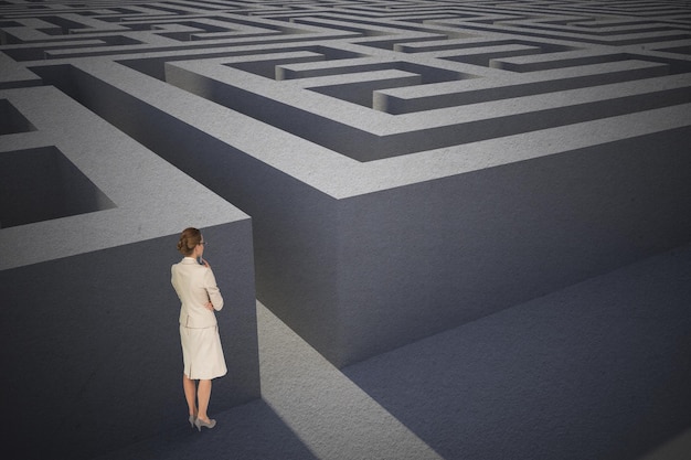 thinking businesswoman against entrance to difficult maze puzzle