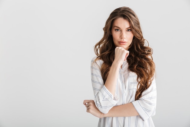 thinking caucasian woman posing and looking at camera isolated over white background