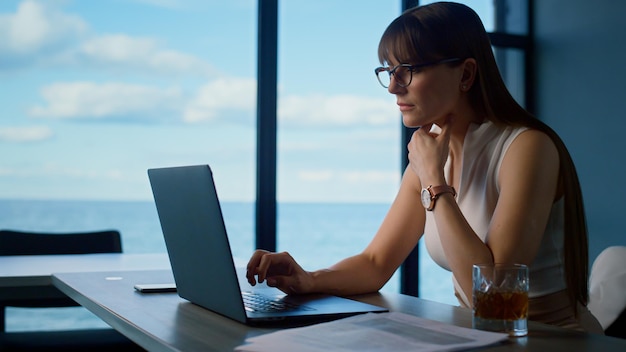 Thinking ceo looking computer screen in office Businesswoman overworking typing