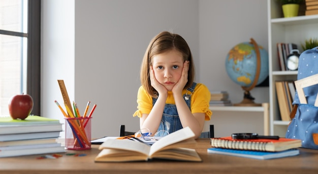 Thinking child is sitting at desk