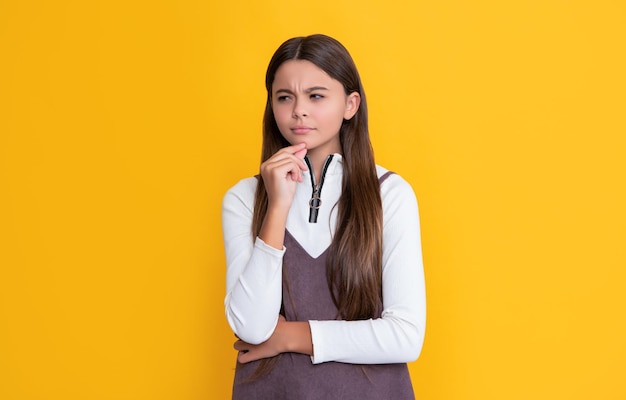 Thinking child with long hair on yellow background