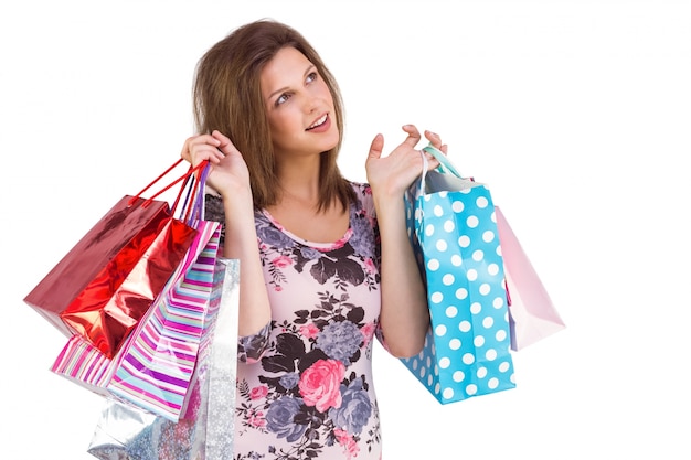 Thinking cute brunette holding shopping bags