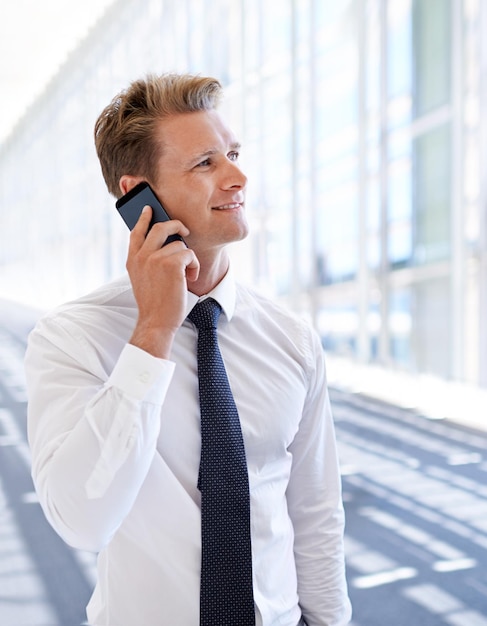 Thinking deal or happy businessman on a phone call talking networking or speaking in office Smile mobile communication chat or proud entrepreneur in conversation discussion or negotiation offer