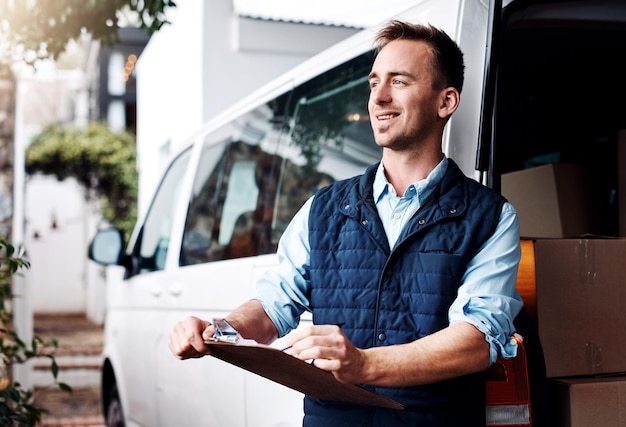 Foto pensare alla consegna e un corriere con documenti vicino al suo furgone con in mano un blocco per appunti per un ordine o un indirizzo e-commerce logistico o fornitura con un autista maschio che trasporta una lista di controllo per la spedizione dell'inventario