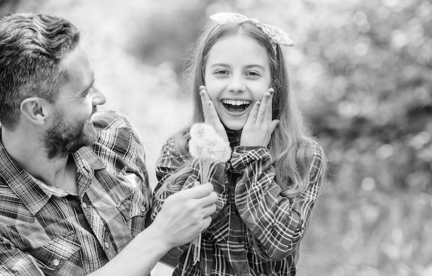 エコロジーを考える小さな女の子と幸せな男のお父さん地球の日春の村の国の家族夏の農場の生態学幸せな家族の日の娘と父はタンポポの花が大好きです