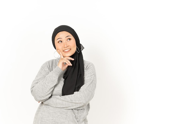 Gesto di pensiero della bella donna asiatica che indossa l'hijab isolato su sfondo bianco