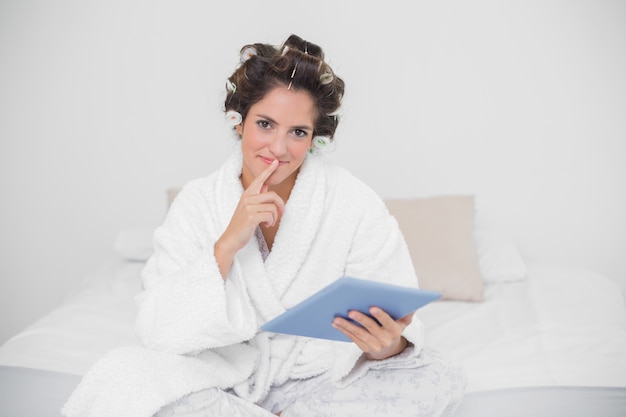 Thinking natural brunette holding tablet