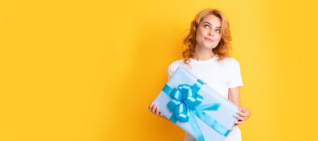 Thinking redhead girl with present box happy birthday Beauty woman isolated face portrait banner with mock up copy space