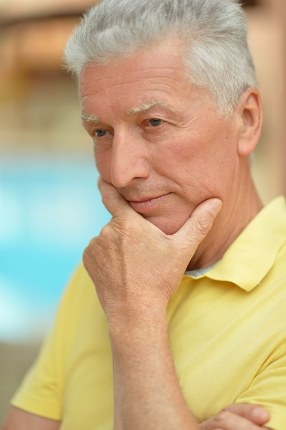 Thinking smiling senior man at the resort