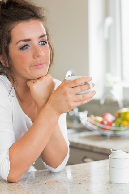 コーヒーを持っている思考している女性