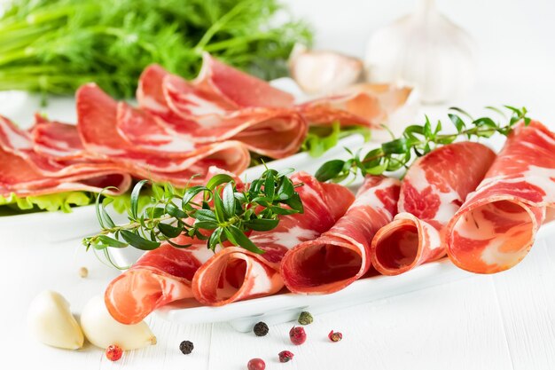 Thinly sliced ham on a narrow white plate