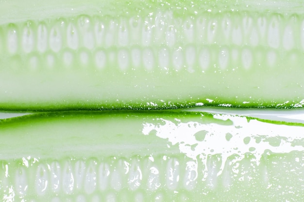 Thinly sliced lengthwise slices of fresh green cucumber on a white background