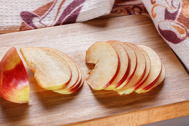 Thinly sliced slices of fresh apple on a kitchen board.