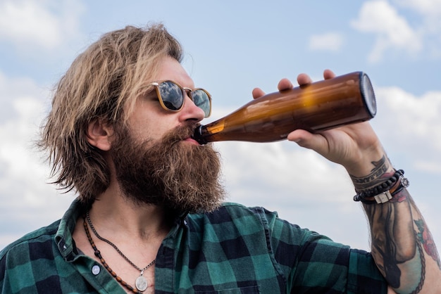 Thirsty brutal handsome man with moustache drinking water water balance in body stay hydrated relax and refreshment modern looking bearded hipster drink beer alcohol concept