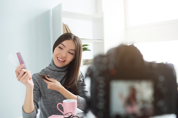 This beauty blogger is recording video about hair care and hair tips