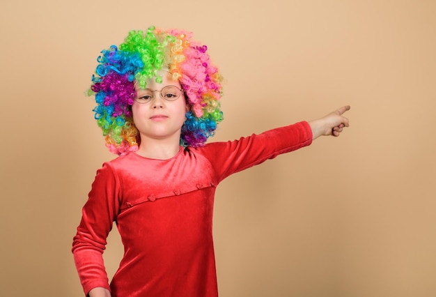 This direction Girl cute playful child wear curly rainbow wig Life is fun Happy childhood Happy little girl International childrens day Child care Happy moments Adorable baby having fun