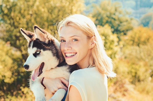 This girl loves her siberian husky sexy woman with dog pet on\
summer day happy girl hold pedigree dog happy dog owner play with\
family pet outdoor husky is for young at heart with smiling\
eyes