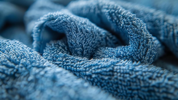 Фото Это крупный план голубого полотенца. полотенце складывается и скручивается, создавая мягкую и приятную текстуру.