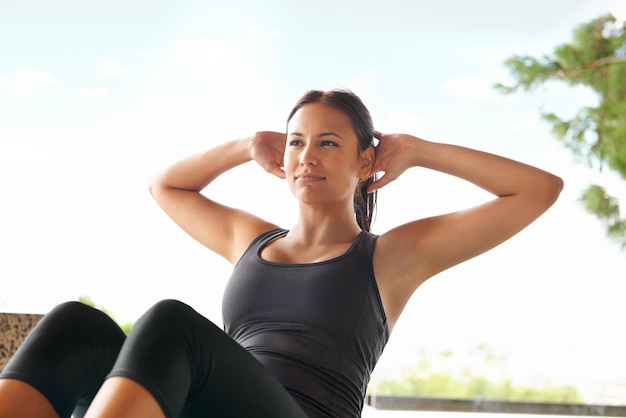 This is easypeasy for her Shot of a sporty young woman doing situps outside