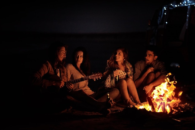 이것은 자유의 느낌 밤에 해변에서 모닥불 주위에 앉아 친구의 그룹 샷