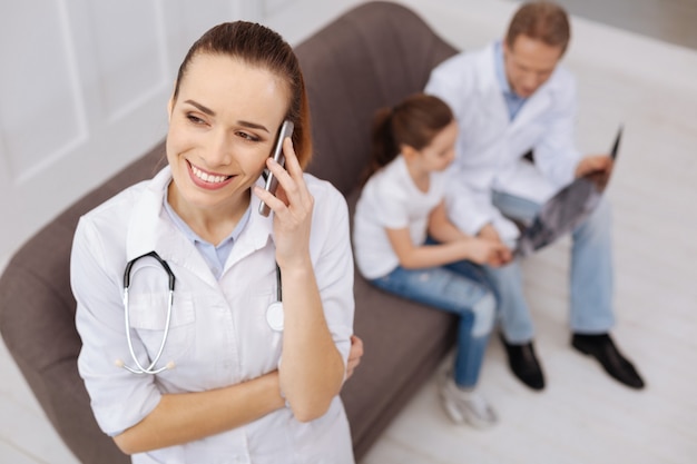 This is great. Delighted nice dedicated doctor smiling while calling her little patients mother for explaining her great progress of her daughter