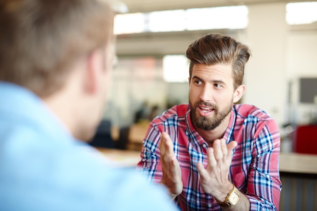 これは私がそれを見る方法ですオフィスでの仕事について話し合っている2人の同僚のショット