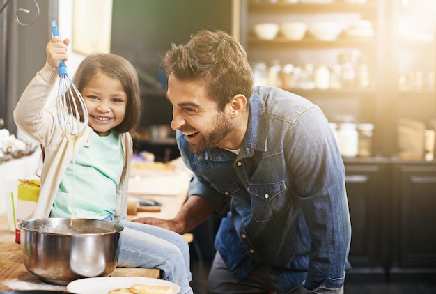 Foto ecco come preparare la pastella perfetta per i pancake. foto di padre e figlia che preparano i pancake insieme