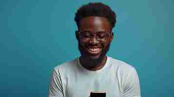 Photo this is an image of a happy africanamerican millennial guy holding a smartphone looking at the gadget screen and smiling on a blue studio background information about black men gambling and gaming