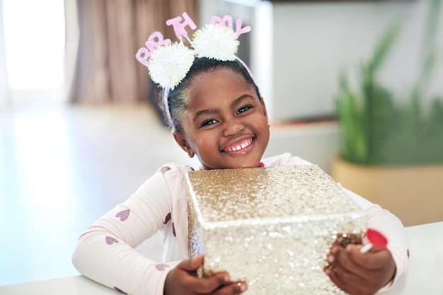 This is for me Shot of a little girl holding on to a gift box on her birthday