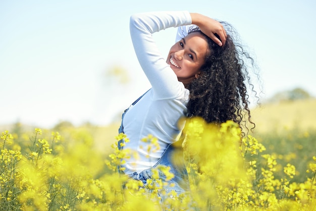 Questo è l'unico posto che mi fa sentire così. inquadratura di una giovane e bella donna in un campo di colza in fiore.