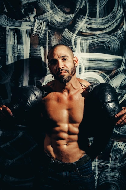 This is a portrait of a martial arts fighter or boxer with boxing gloves on a dark background