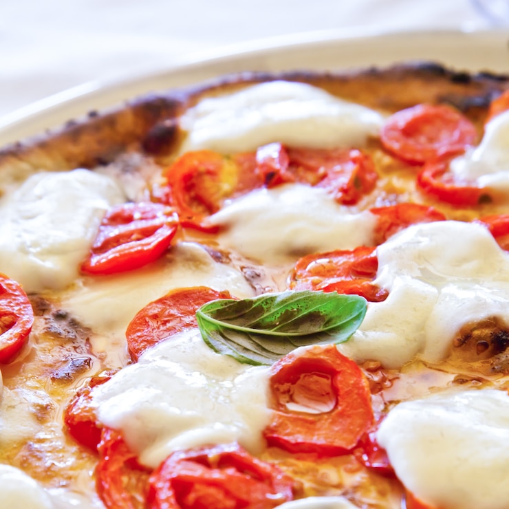 Photo this is a true italian pizza. traditional pizza margherita served in a capri's restaurant, naples gulf, italy.