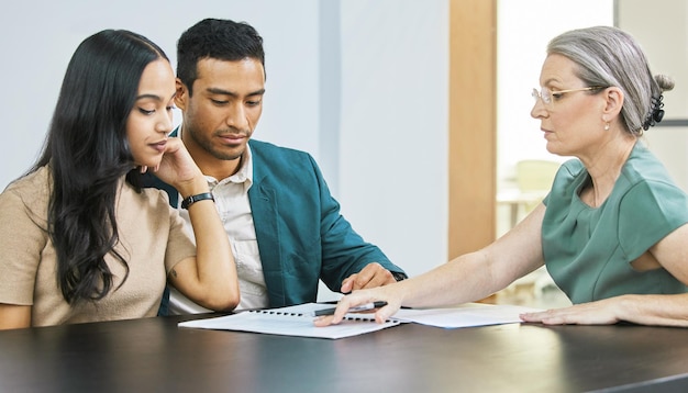 Photo this is what your finances look like cropped shot of a young couple going over some paperwork during a meeting with their financial advisor