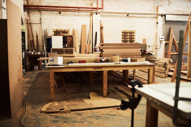 Photo this is where all the magic happens still life shot of work tables and piles of wood inside a carpentry workshop