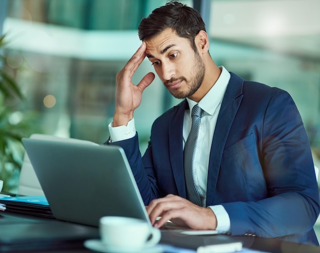 This isnt good Shot of an stressed executive working on a laptop in an office