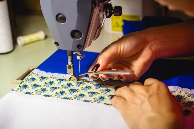 In this photo illustration a seamstress threading a sewing machine to work in the fashion workshop.