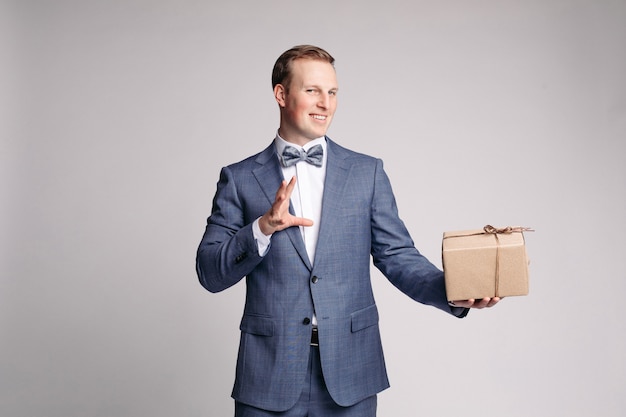 This present is for you Part of man in suit showing present box with smile while standing against white background