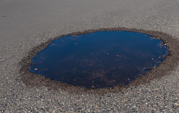 This puddle on the asphalt is a reminder of the dynamic interplay between nature and infrastructure