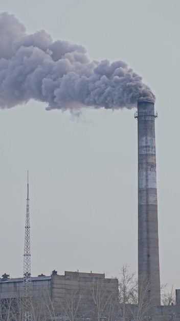 This smoke coming from the chimney in a factory. harmful\
emissions into the atmosphere, from the pipe. serious damage the\
environment. plant stack coaling station. close up shot. dark sad\
view.