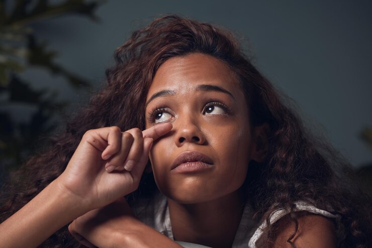 Photo this too shall pass closeup shot of a young woman wiping her tears while sitting at home