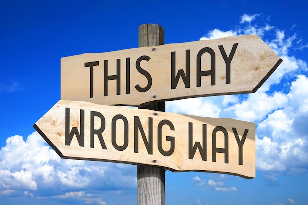 This way wrong way wooden signpost with two arrows sky with clouds in background