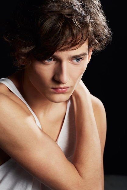 Photo thought consumes him portrait of a thoughtful young man wearing a vest while posing against a black background