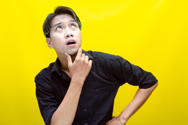 Thoughtful asian man thinking and wondering with hand touching skin as thinking gesture isolated