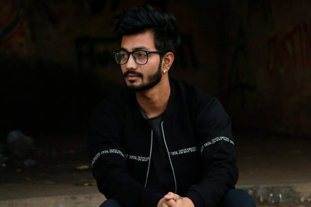 Photo thoughtful bearded man looking away while sitting outdoors