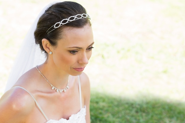 Thoughtful bride looking away in garden