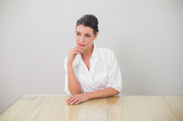 Thoughtful brunette businesswoman posing