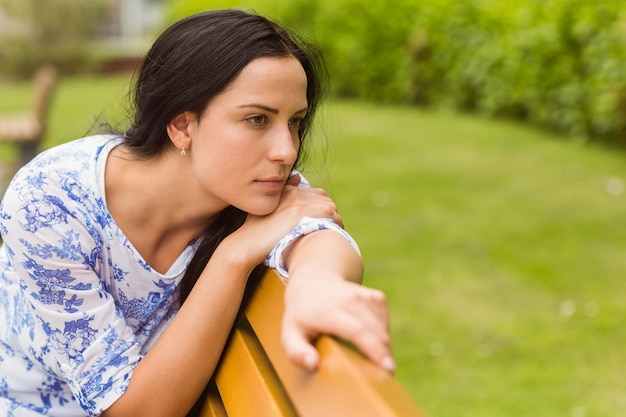 Thoughtful brunette sitting on bench 