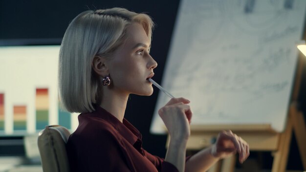 Photo thoughtful business woman analyzing charts on computer in night office