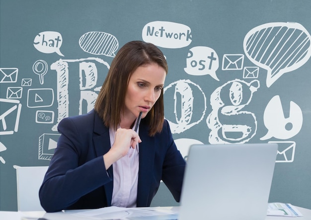 Thoughtful business woman at a desk  looking at a computer against blue background with graphics