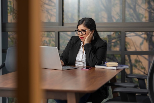 Фото Вдумчивая бизнес-женщина во время работы днем в офисе